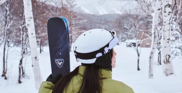 Esquiadora caminhando na neve com equipamento de ski em resort Club Med nos Alpes.