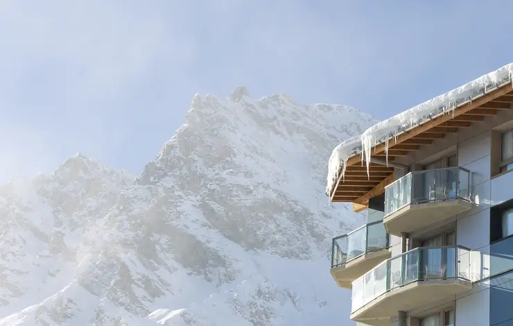 Resort de neve nos Alpes com vista para montanhas cobertas de neve.