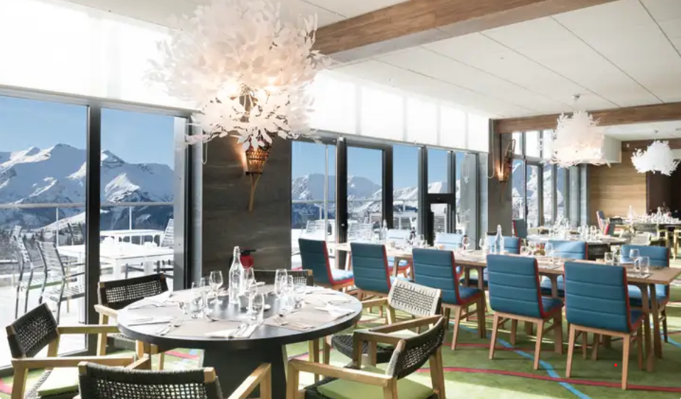 Restaurante panorâmico em resort Club Med nos Alpes com vista para montanhas nevadas durante férias de ski na Europa.