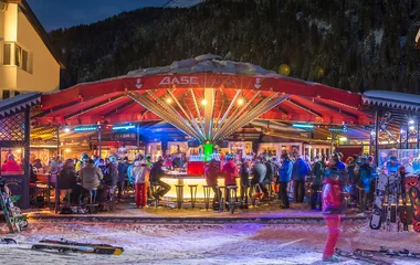 Bar de après-ski à noite em estação de ski nos Alpes.