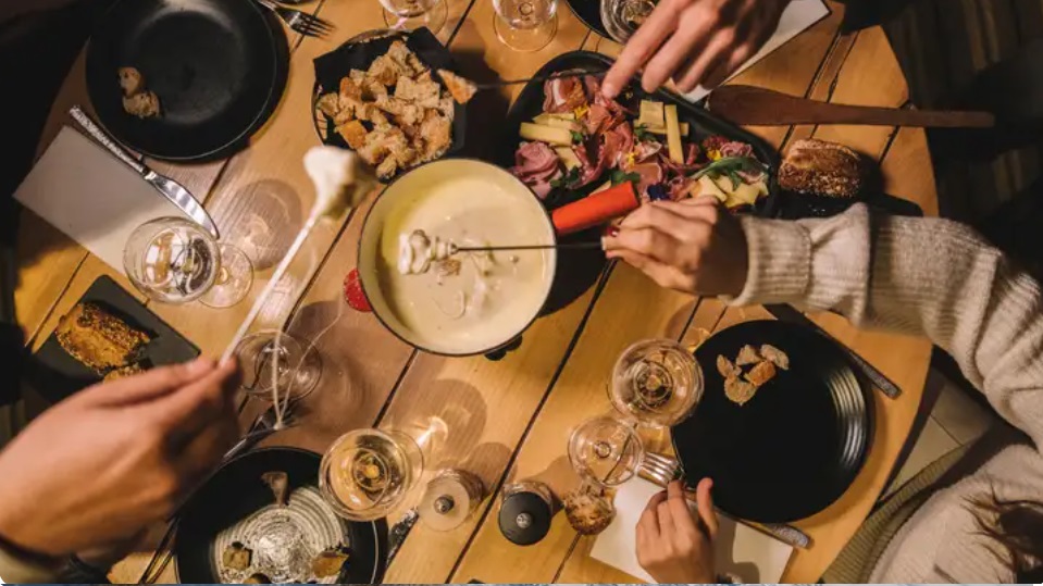 Fondue e pratos alpinos servidos em resort Club Med durante férias na neve.