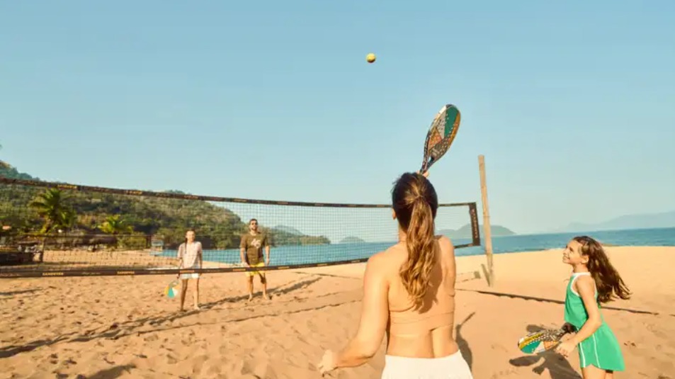 Família jogando esporte na praia em resort all inclusive Club Med durante férias em família