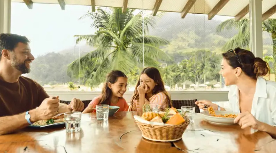 família sorrindo durante refeição em resort Club Med